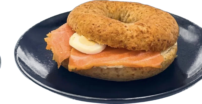 Bagel mit Lachs und Ei auf dunklem Teller