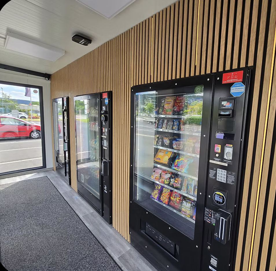 Innenraum eines FlavourFlo-Kiosks mit Holzlamellen und Snackautomaten