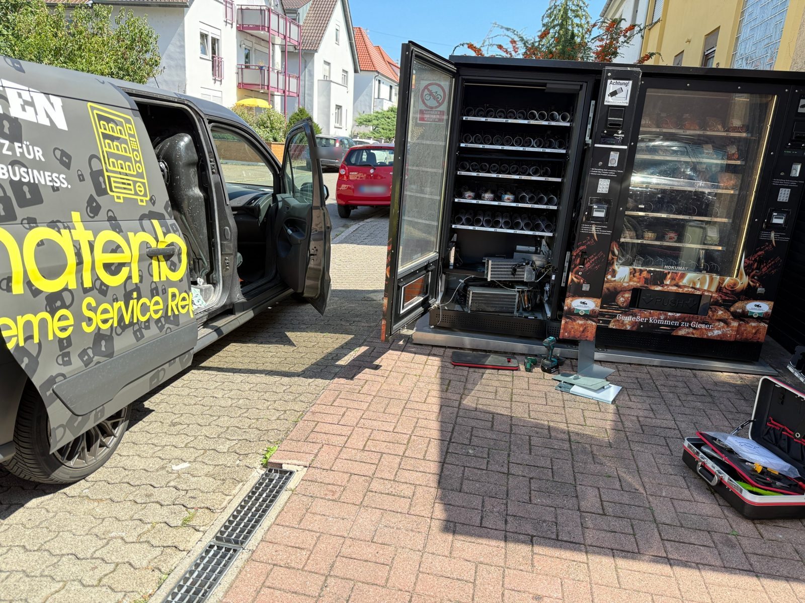 AutomatenBuddy-Servicefahrzeug neben einem geöffneten Verkaufsautomaten bei der Reparatur vor Ort